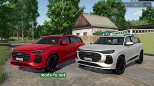 Two Audi SUVs, red and white, parked side by side on a gravel driveway with a rural house and green trees in the background.